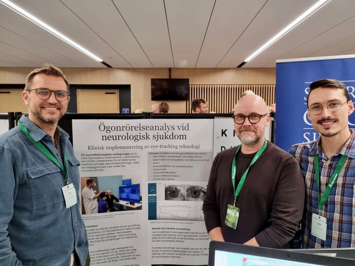 Tre män står framför en poster.