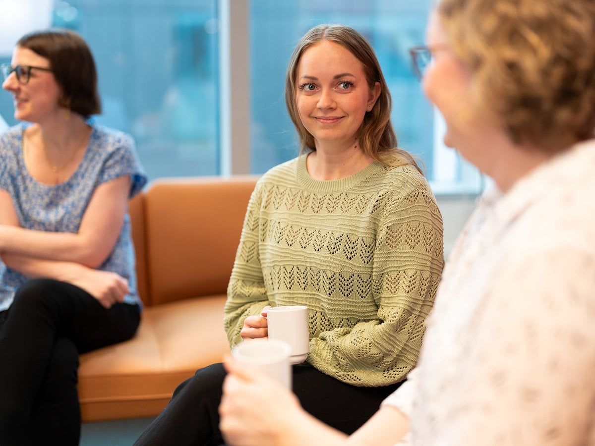 Tre kvinnor dricker kaffe.