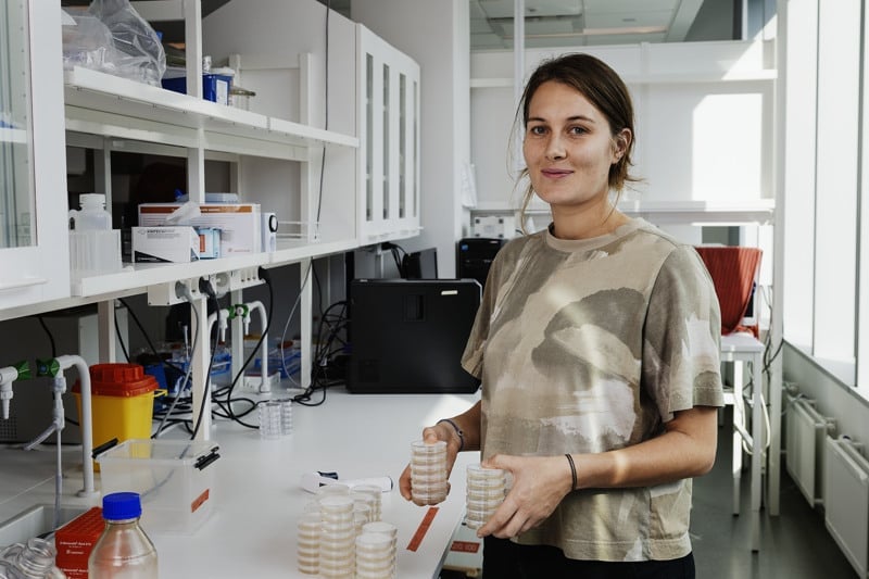 En kvinna står i ett laboratorium och håller i en näbb.