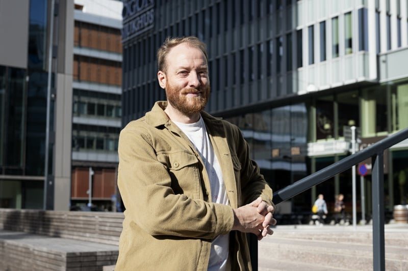 En man står framför en byggnad.