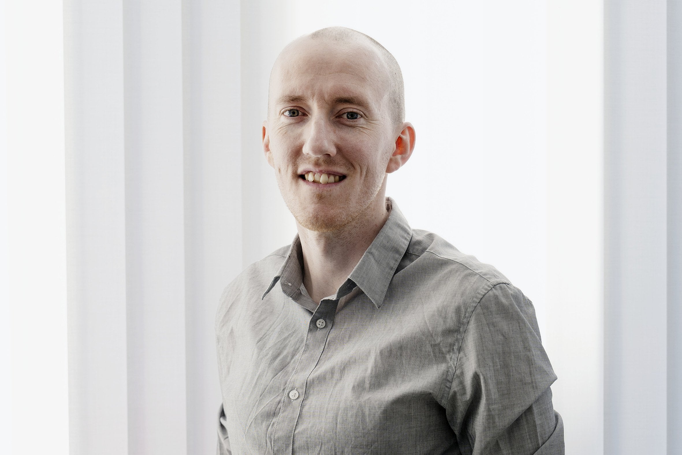 En man som står framför ett fönster med händerna i fickorna.