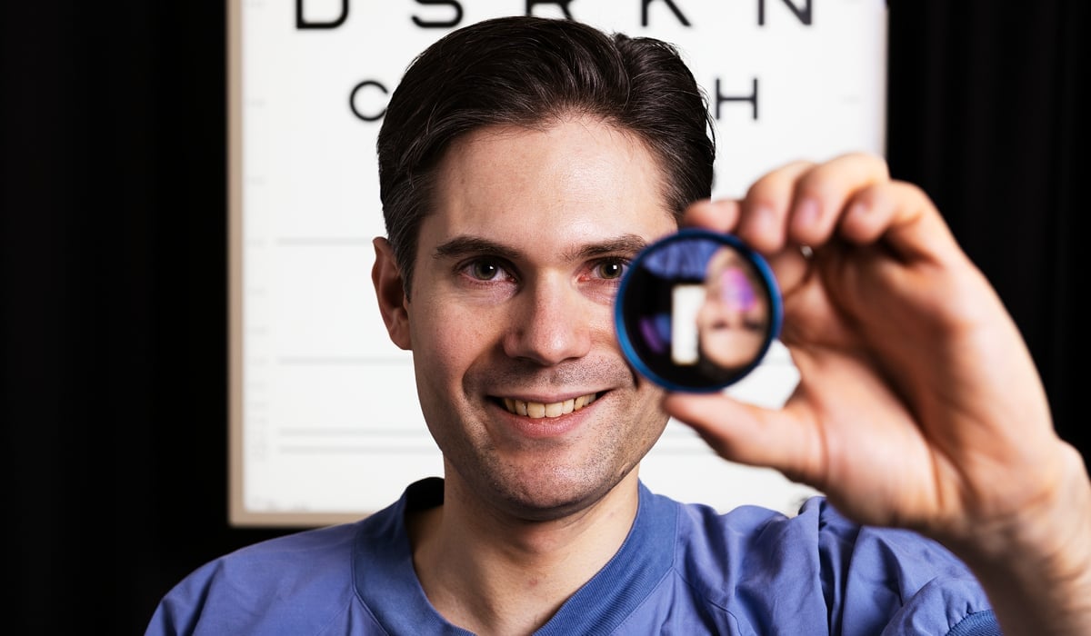 En man håller ett förstoringsglas framför sin ögonkarta.