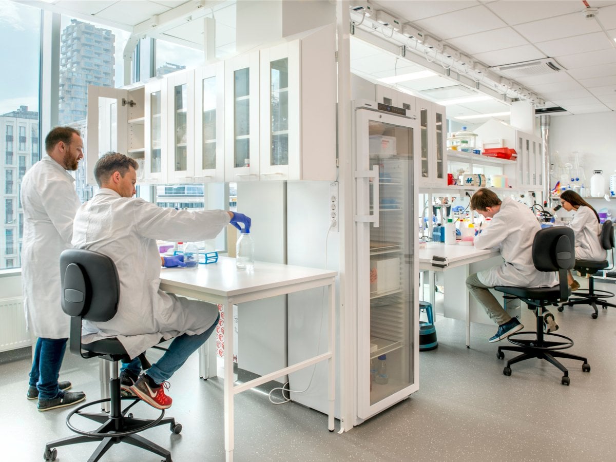 Fyra personer i ett laboratorium, Alla fyra har labbrockar på sig.