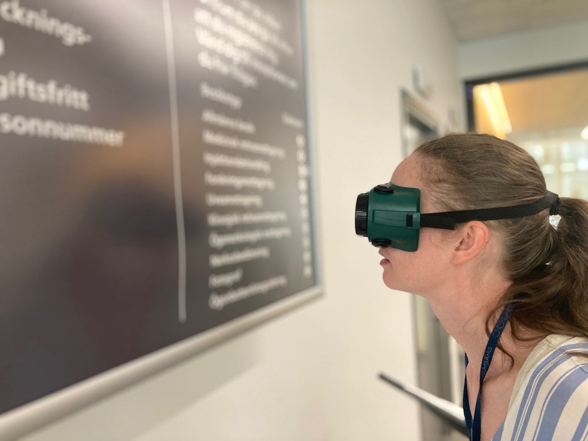 En kvinna med ett par glasögon som begränsar synen. Hon står framför en svart tavla.