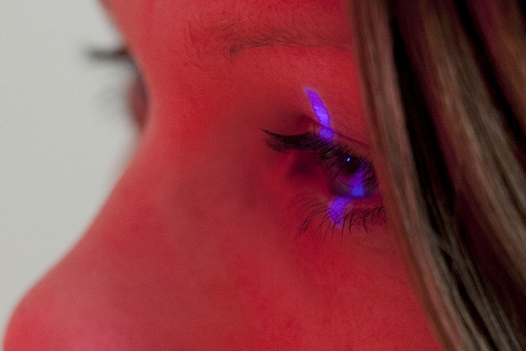 En laserstråle lyser på den undersökta kvinnans ena öga.